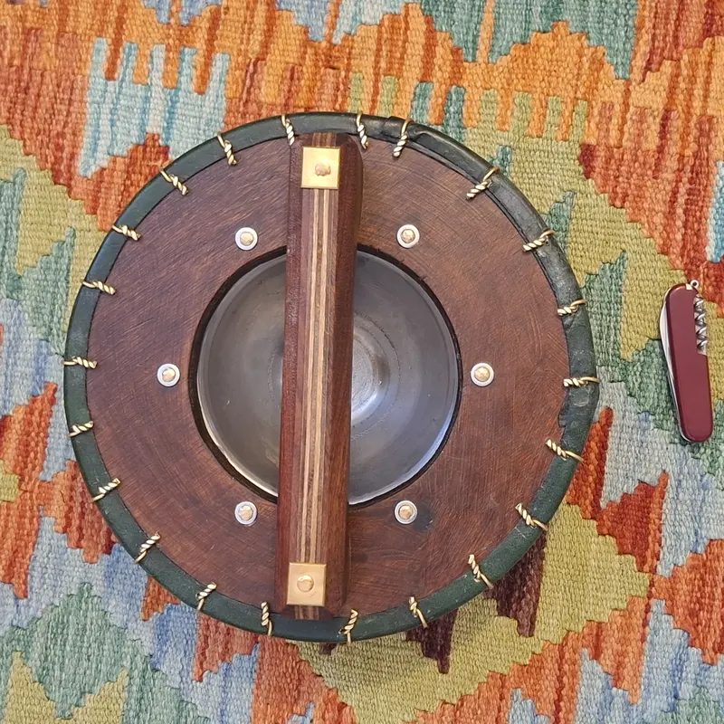 The back of the round buckler, showing the hardwood grip across the boss
