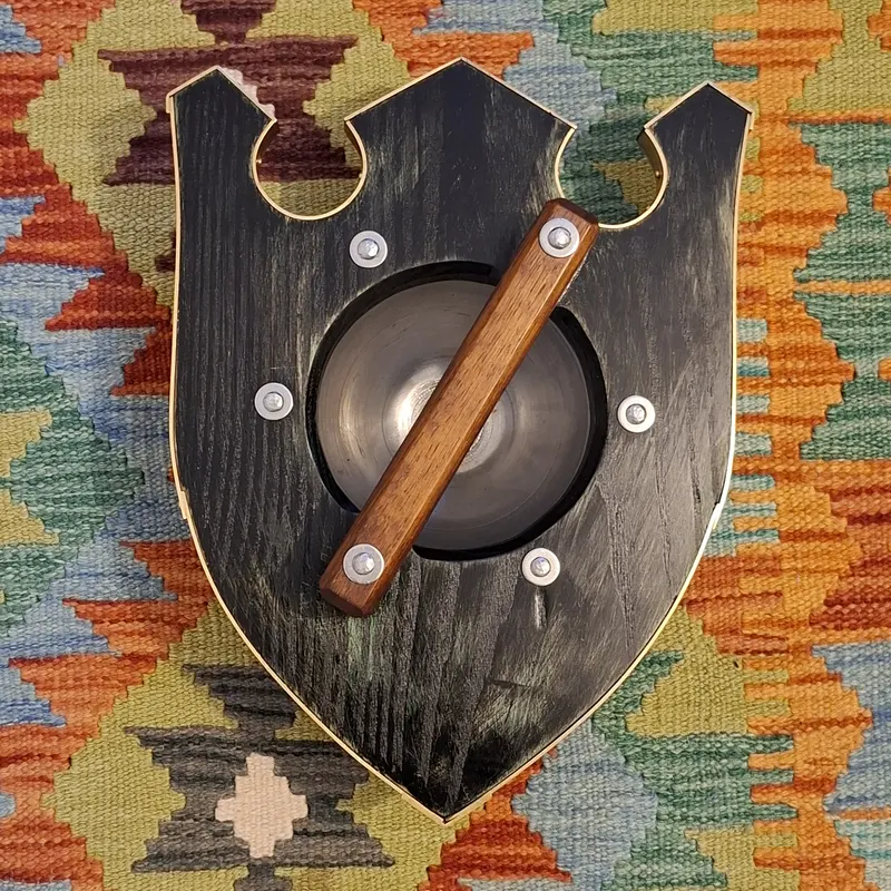 The back of the shaped buckler with its wooden grip