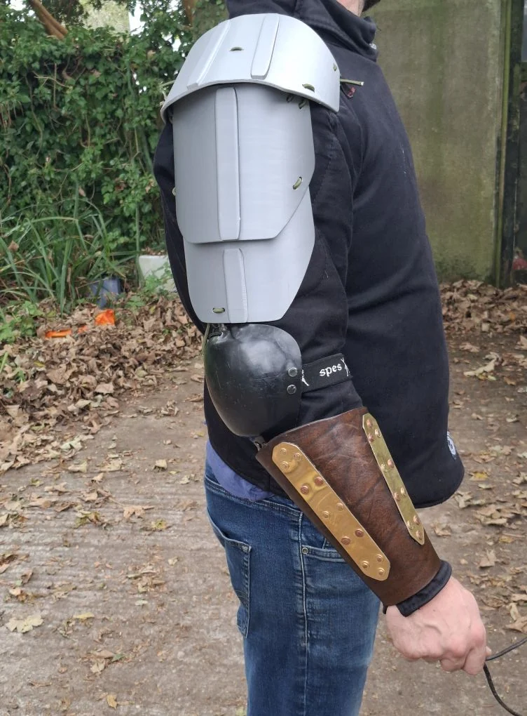 George's 3D-printed shoulder armour worn over a SPES HEMA jacket, with one of his earlier brass-plated bracers below