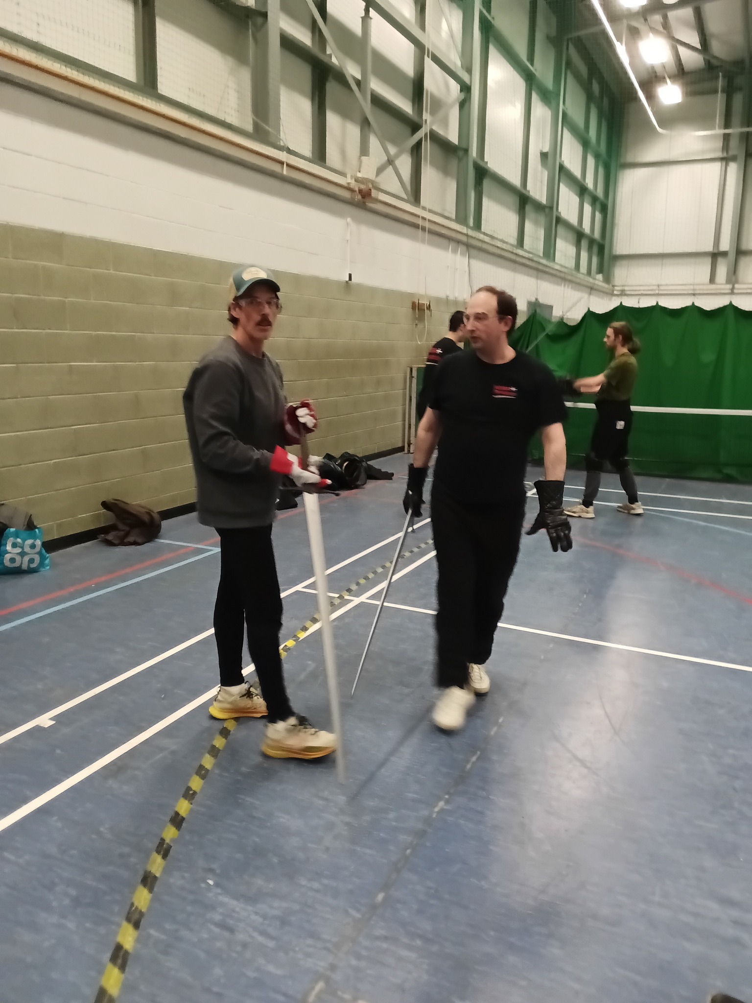Members chatting between bouts with swords in hand