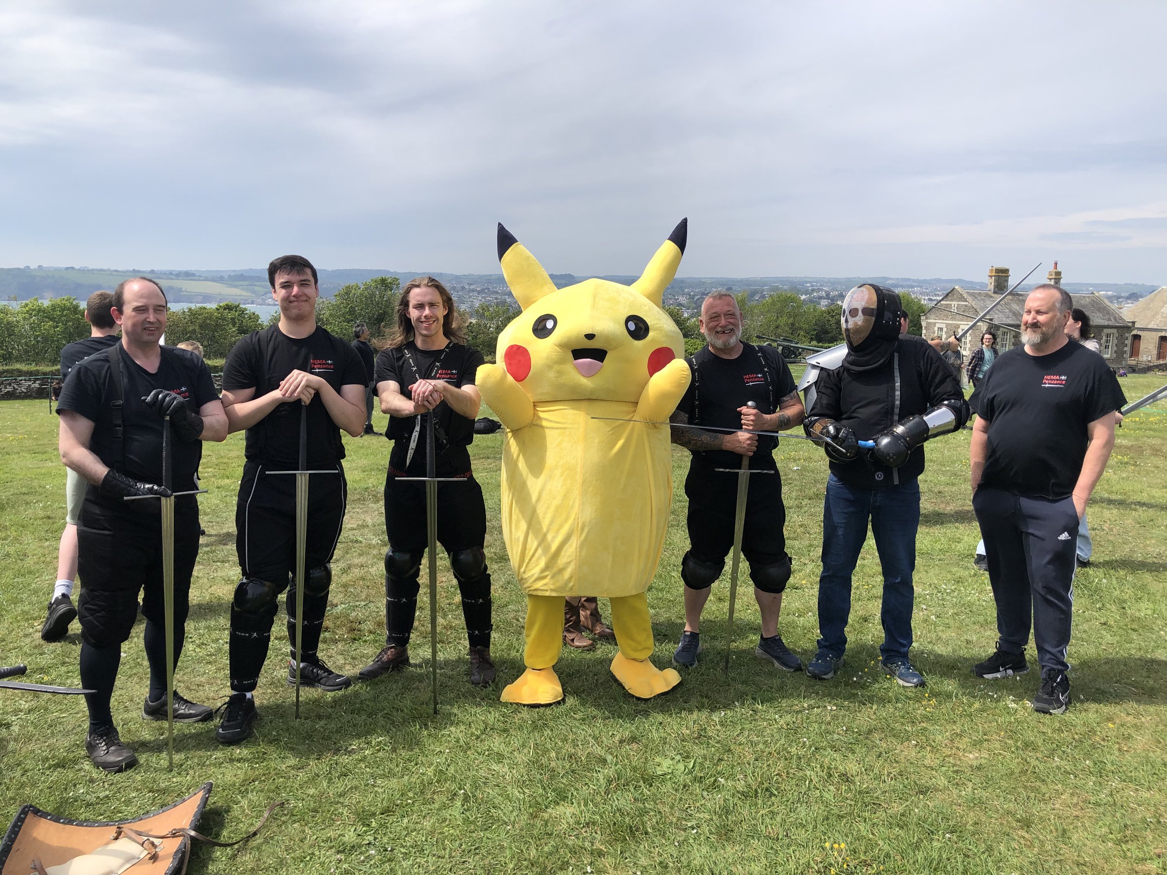 HEMA Penzance members lined up with longswords alongside a Pikachu mascot at FABLEFUSION