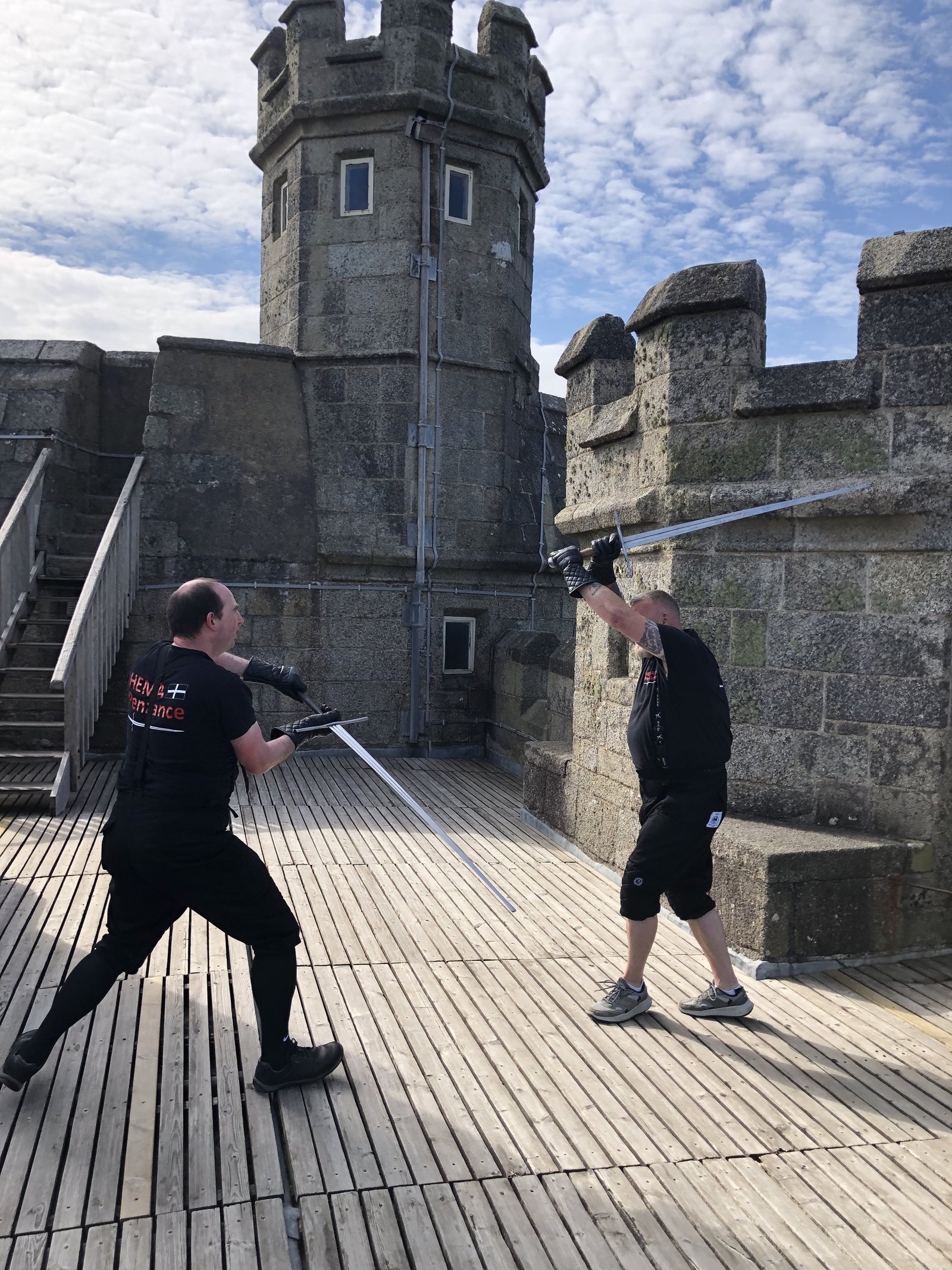 Two HEMA Penzance members sparring atop a Pendennis Castle rampart