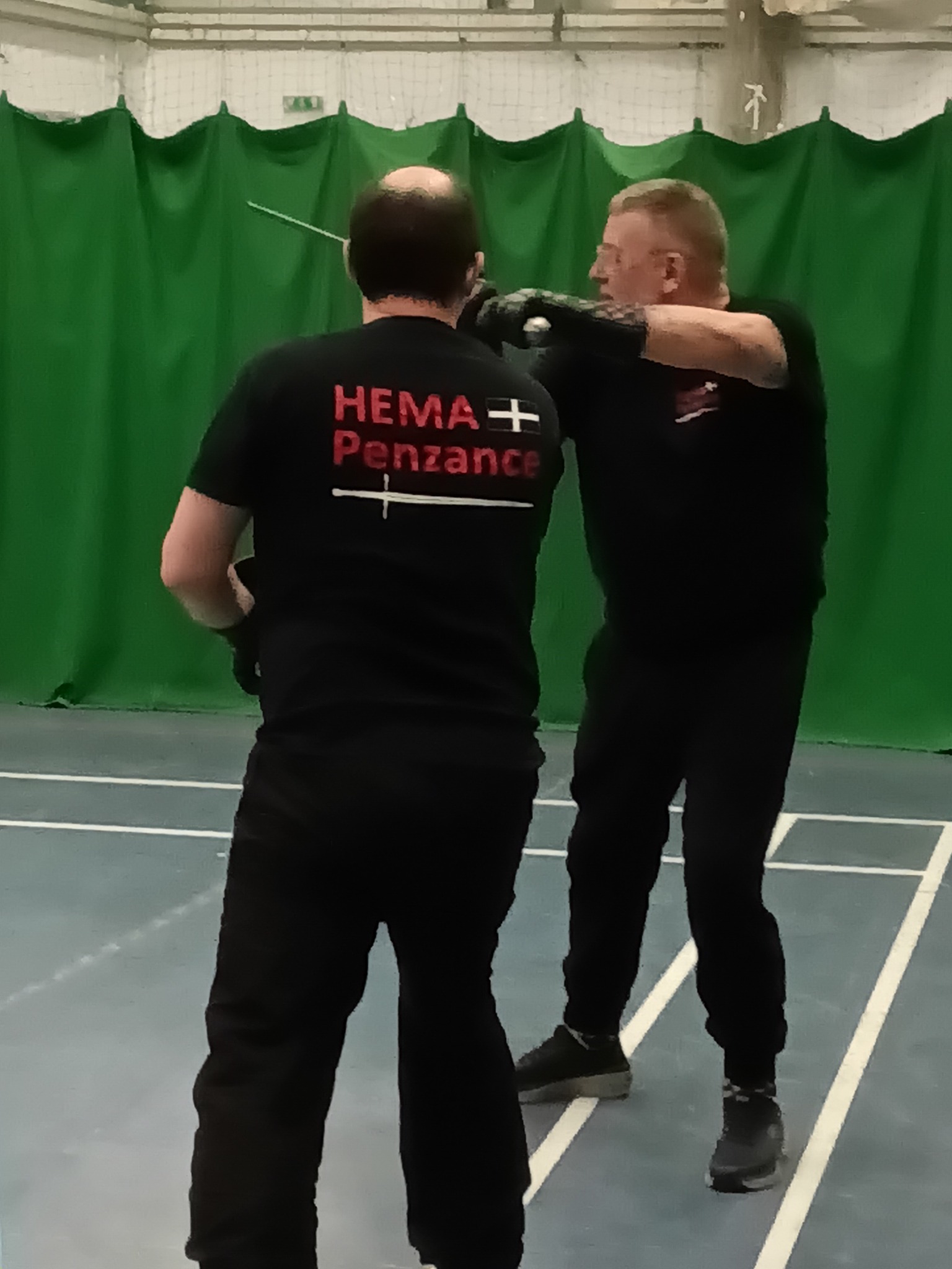Close-quarters grapple showing the club t-shirt